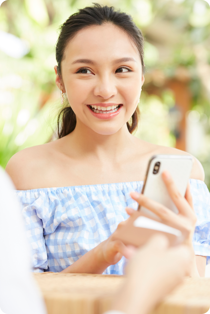 スマホでタイ語を学ぶ笑顔の女性